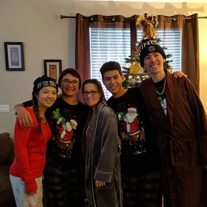 DeVera Brown and her four kids in matching Christmas pajamas in front of the Christmas tree